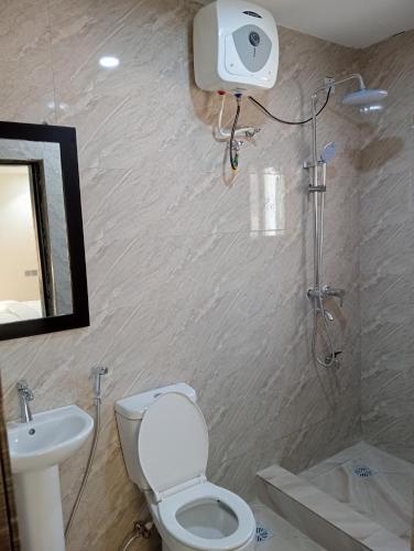 a bathroom with a toilet and a sink and a shower at Pinefield Courts Apartment in Akure