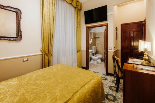a hotel room with a bed and a bathroom at Hotel Posta in Reggio Emilia