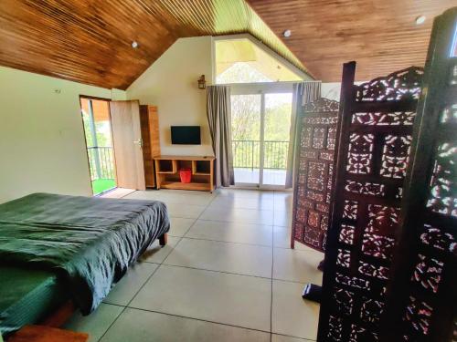 a room with a bed and a desk with a television at The Vagabond Stays in Vagamon
