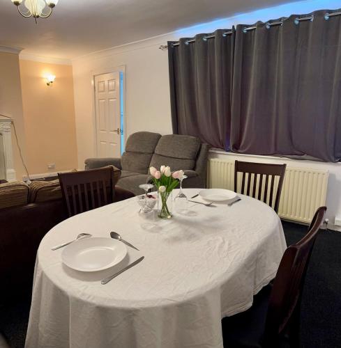 a white table with a vase of flowers on it at Vicky and sons Ltd Sunderland in Monkwearmouth