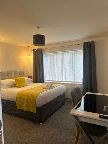 a bedroom with a bed with a yellow blanket and a window at The Villas holiday homes in Horden