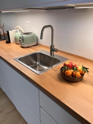 a kitchen counter with a sink and a bowl of fruit at Chianti's Secret Nest - Cozy home with sunset view in Impruneta