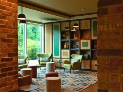 a living room with chairs and tables and a large window at B&B HOTEL Warrington in Warrington