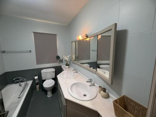 a bathroom with two sinks and a toilet and a tub at Vista Mare Sliema in Sliema