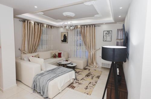 a living room with a white couch and a bed at Greis Home in Maliq