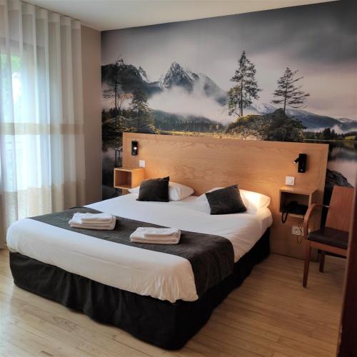 a hotel room with a large bed and a painting on the wall at Hôtel Le Chalet in Ax-les-Thermes