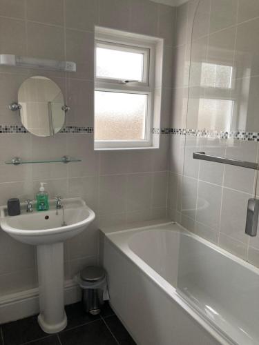 a bathroom with a tub and a sink and a bath tub at Awel Deg in Pembrokeshire