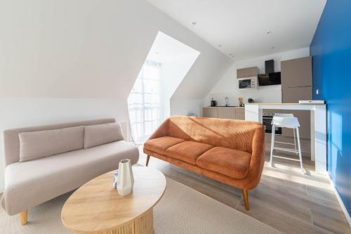 a living room with a couch and a table at La perle de Montargis - Charmant T2 in Montargis