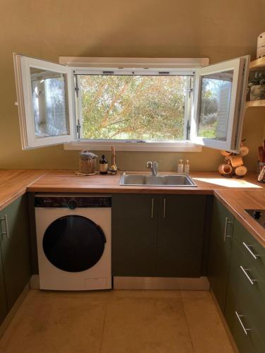 a kitchen with a sink and a microwave at Papiri Beach Summerhouse in Agios Georgios