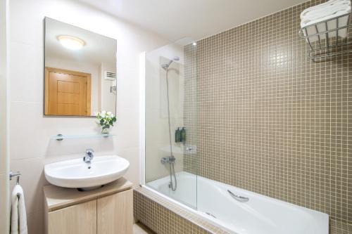 a bathroom with a sink and a shower and a tub at Pierre & Vacances Sevilla in Seville