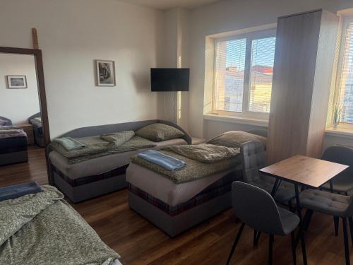 a living room with two beds and a table at Ubytovanie Nitra in Nitra