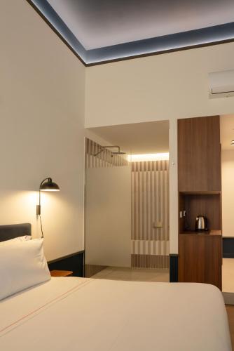 a bedroom with a white bed and a bathroom at Maison Petronilla in Naples