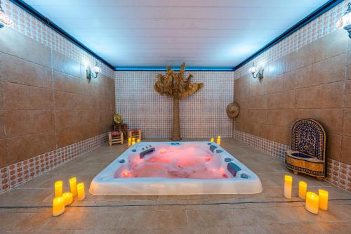 a jacuzzi tub in a bathroom with yellow candles at Suites Romantiques avec Jacuzzi - Marne-La-Vallée - Le Jardin De Vos Secrets in Mouroux