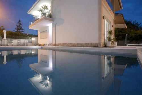 a villa with a swimming pool at night at Gold Coast Photography Inn Cascais in Estoril