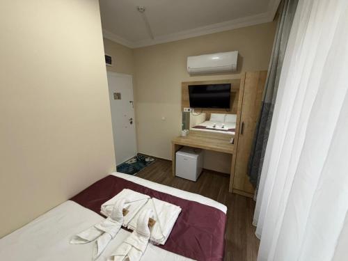 a small room with a bed and a desk at Alpaslan Otel Pansiyon in Antalya