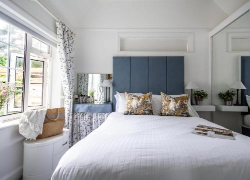 a bedroom with a large bed with a blue headboard at Quayside Cottage in Waldringfield