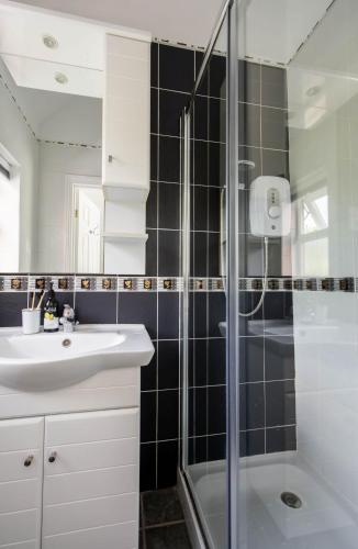 a bathroom with a sink and a shower at Quayside Cottage in Waldringfield