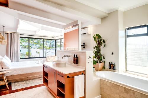 a bathroom with a tub and a sink and a tub and a bath tub at Song of Ascent in Cape Town