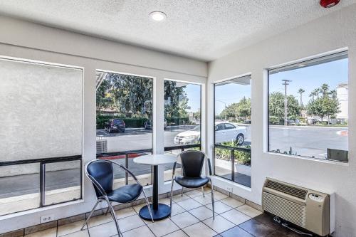 a room with a table and chairs and windows at Motel 6 Modesto, CA in Modesto