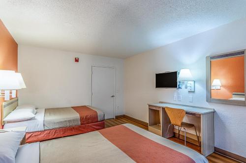 a hotel room with two beds and a desk at Motel 6 Modesto, CA in Modesto