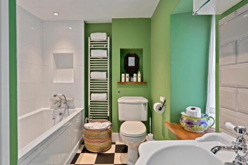 a bathroom with a toilet and a tub and a sink at Finest Retreats - Meadowsweet Cottage in Wingfield