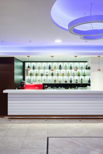 a bar in a restaurant with a shelf with bottles of wine at New City Hotel & Restaurant Niš in Niš