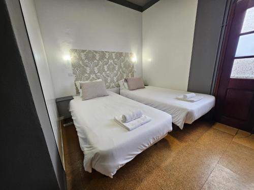 two beds in a small room with white sheets at Sleep and Go in Santana in Nature B&B in Santana