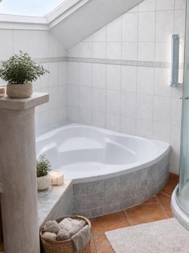 a white tub in a bathroom with a potted plant at GreenHell Stays Müsch - Nürburgring in Müsch