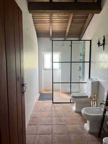 a bathroom with two toilets and a walk in shower at Monte do Vale in Casa Branca