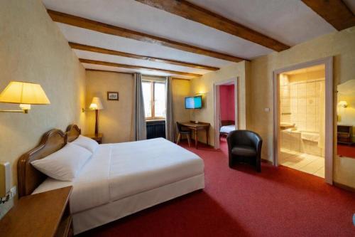 a hotel room with a white bed and a bathroom at Hôtel A la Vignette - COLMAR-NORD in Saint-Hippolyte