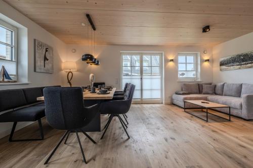 a living room with a table and chairs and a couch at Doppelhaushälfte Strandgut 4 in Sylt