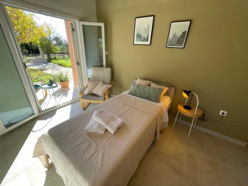 a bedroom with a large bed and a large window at Papiri Beach Summerhouse in Agios Georgios