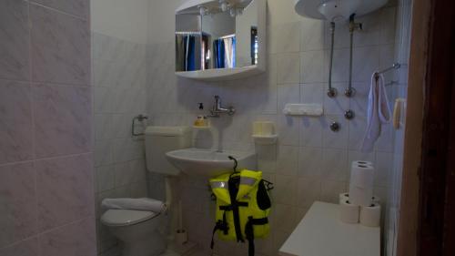 a small bathroom with a toilet and a sink at VIScovery apartments in Vis