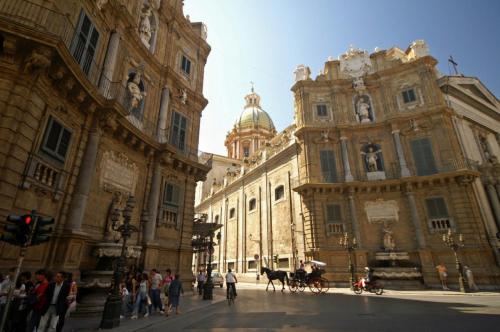 um grande edifício com pessoas e um cavalo à frente dele em Loggiato Palazzo San Matteo em Palermo