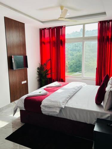 a bedroom with a bed with red curtains and a window at Breezy bluff in Madikeri
