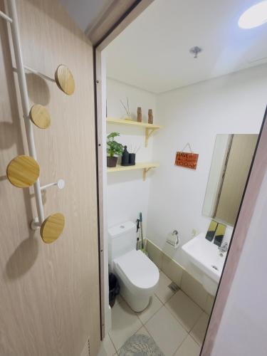 a bathroom with a toilet and a sink at Ellain's Cozy Staycation-SMDC Green 2 Residences in Dasmariñas