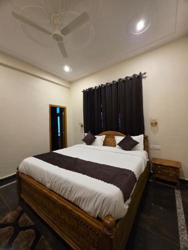 a bedroom with a large bed with black curtains at Pi Palace in Bhīm Tāl
