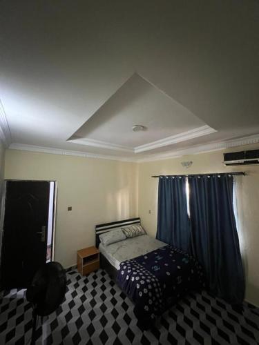 a bedroom with a bed and a blue curtain at Funkytee Apartments in Isasi