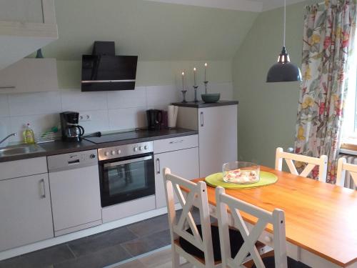 a kitchen with a wooden table and a dining room at Ferienwohnung am Wind mit Dachterasse in Bredstedt