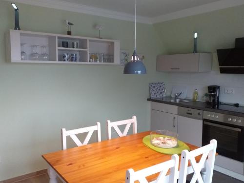 a kitchen with a wooden table with a plate of food on it at Ferienwohnung am Wind mit Dachterasse in Bredstedt