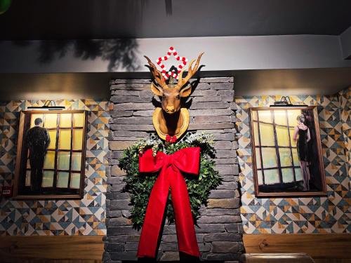 a reindeer head with a red bow on a wall at Yalı Bahçe Mudanya in Burgaz