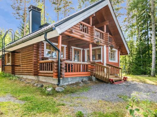a log cabin in the woods with a large porch at Holiday Home Tallukka by Interhome in Pertunmaa