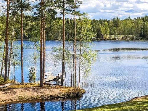 a bench sitting on the edge of a lake at Holiday Home Inkeri by Interhome in Holiseva