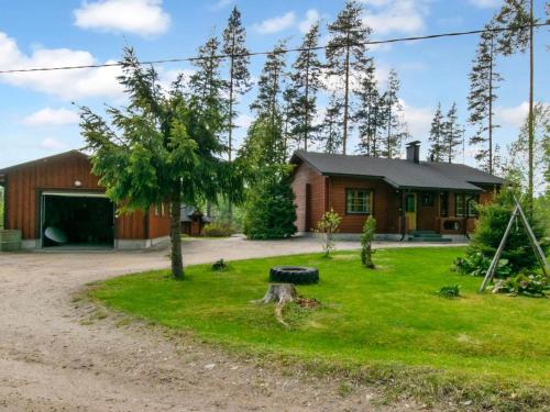 a house with a tire in front of a yard at Holiday Home 7152 by Interhome in Kaartilankoski