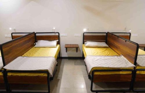two beds in a room with a table at Sukhnidras Dormitory in Hyderabad