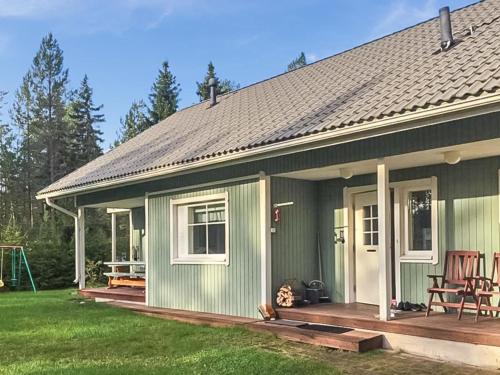 a green house with a porch and a patio at Holiday Home Merivanamo by Interhome in Haukipudas
