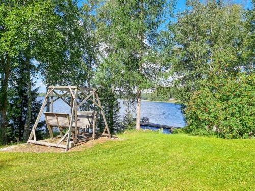 a swing in the grass next to a lake at Holiday Home Saarenpää by Interhome in Koivisto