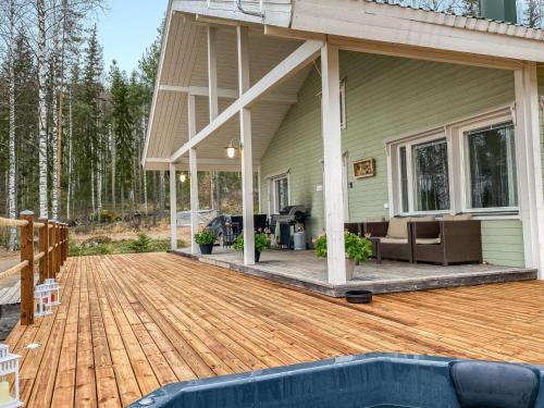a house with a wooden deck with a swimming pool at Holiday Home Villa sipilä by Interhome in Savonranta
