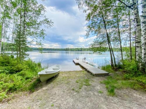 a boat parked next to a dock on a lake at Holiday Home Villa sipilä by Interhome in Savonranta