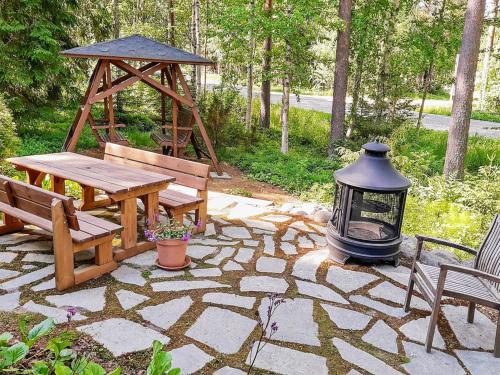 a stone patio with a table and a gazebo at Holiday Home Eskola by Interhome in Lahdenperä